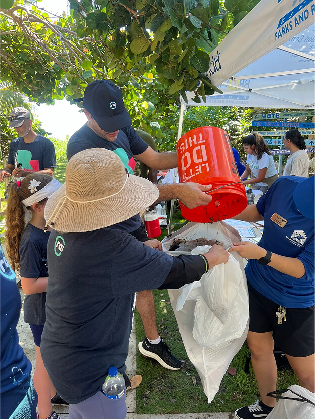 people pulling a can into a bag